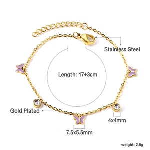 Détail du bracelet en acier inoxydable doré avec des breloques papillon et cristaux blancs