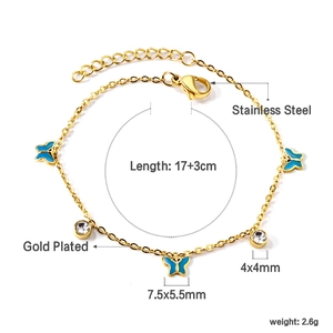 Détail d'un bracelet en acier doré avec papillons bleus et zircons ronds brillants