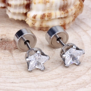 Gros plan de boucles d'oreilles étoiles argentées avec zircons sur fond de bois