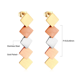 Macro view of geometric fringe earrings with brushed stainless steel finish and layered design