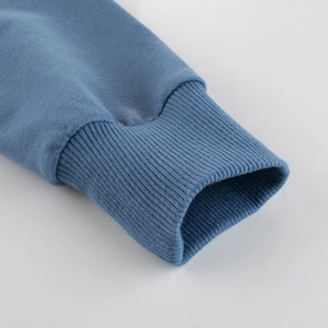 Nahaufnahme der gerippten Manschette eines blauen Kinderpullovers aus Baumwolle