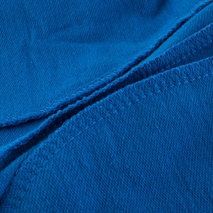 Close-up of blue knit shorts showing high-quality overlock stitching and fabric texture