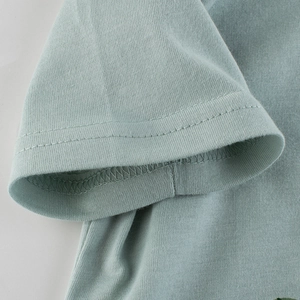 Gros plan d'un t-shirt bleu clair en coton pour garçon avec détails de couture sur la manche