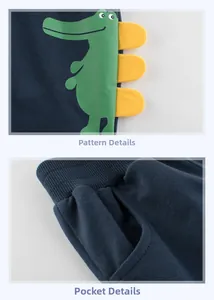 Detail of navy blue kids cotton shorts featuring green crocodile patch and yellow accents