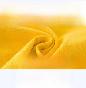 Gros plan sur le tissu en coton jaune doux et respirant pour t-shirts enfants