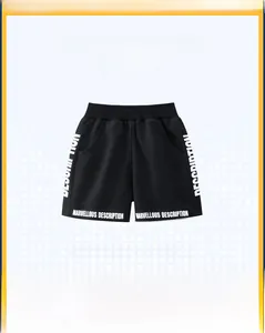 Detail view of boys' black sports shorts featuring elastic waist and white letter prints
