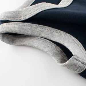 Detail eines dunkelblauen Jungen-Unterhemds mit grauen Rippbündchen und Doppelnaht