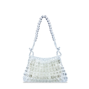Macro detail of hand-woven transparent acrylic beads with a white fabric liner bag