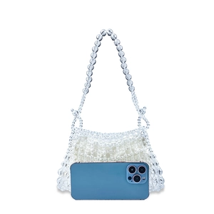 Detail view of handcrafted clear beaded handbag featuring a white fabric inner liner
