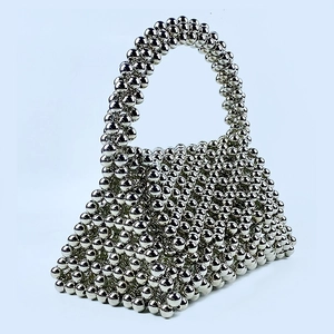 Close-up of a silver beaded bag with a structured trapezoid shape and metallic finish