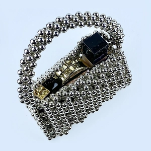 Close-up of silver beaded handbag showing internal space with cosmetics for capacity display