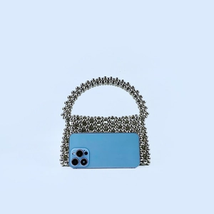 Macro detail of handmade silver beaded hollow handbag showing metallic texture and reflection