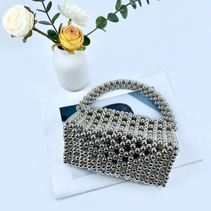 Detailed view of handcrafted silver beaded texture on a stylish hollowed-out flap handbag