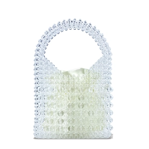 Detailed macro view of handmade clear beaded handbag with a white satin drawstring pouch