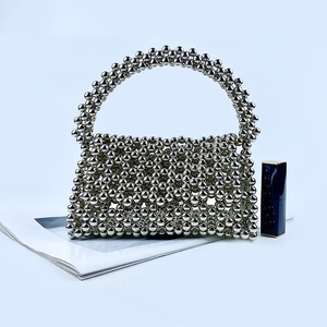 Close-up of handmade silver beaded handbag with metallic finish and woven flap detail