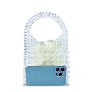 Detail view of handmade clear beaded handbag with white satin lining and phone size reference