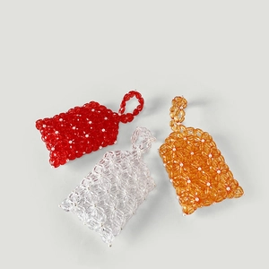 Detailed macro view of handmade acrylic floral beaded bags in red, white and orange colors