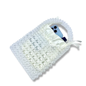 Detail of handmade clear beaded handbag with cream satin drawstring lining insert