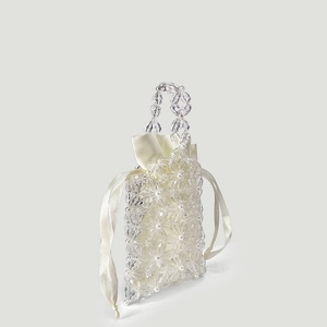 Detail view of handmade acrylic floral beaded bag with pearl accents and satin drawstring lining