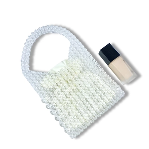 Macro detail of transparent beaded handbag with white silk drawstring liner bag