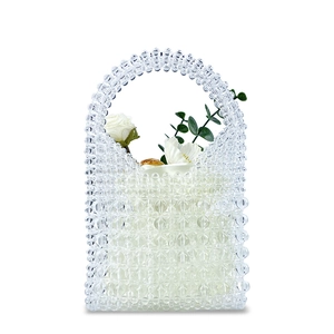 Close-up of clear beaded handbag with transparent pearls and white rose inside