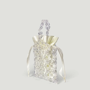 Detail of handmade beaded flower bag featuring acrylic petals and pearl decorations