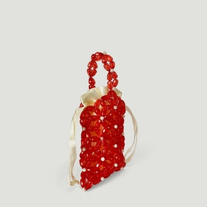 Macro view of red acrylic floral beads and cream satin drawstring inner on handmade bag