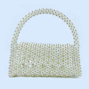 Detailed view of handmade beaded tote bag featuring pearlescent white round beads