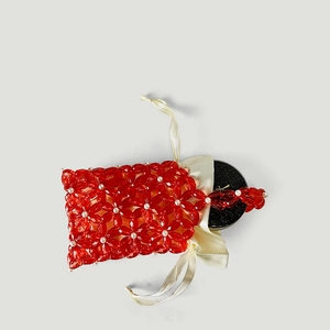 Detail of red floral acrylic beads with pearl centers and beige satin drawstring pouch