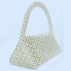 Macro shot of silver beaded texture on a stylish handmade triangle woven handbag