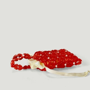 Detail of red acrylic flower beaded handbag with white pearl accents and satin lining