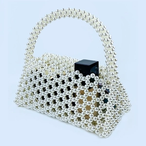Close-up of handmade white pearl woven handbag with elegant vintage beaded texture
