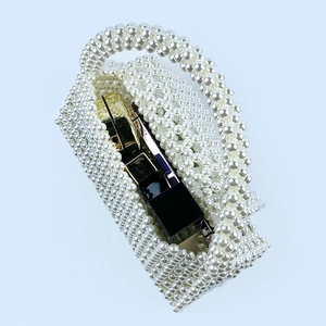 Detailed interior of handmade pearl beaded handbag with lipstick and compact inside