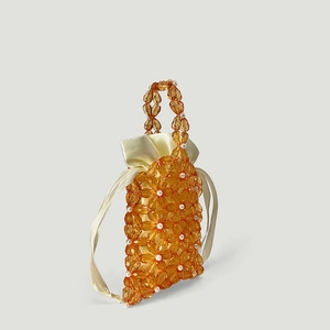 Detail of amber acrylic floral beads and silk drawstring lining on a handmade mini handbag