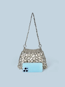 Macro detail of silver metal sequin woven handbag with chain strap and white inner pouch