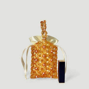 Detail of beaded floral handbag with amber acrylic beads and pearl center accents