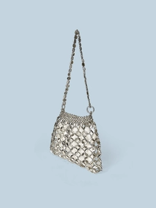 Detail of silver metallic disc chainmail handbag with a white fabric inner pouch