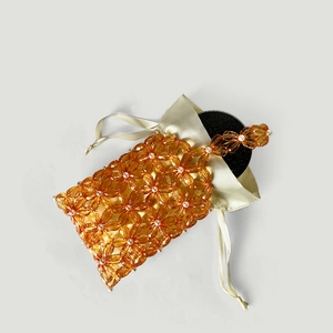 Detail of orange acrylic flower beaded handbag with champagne satin drawstring liner pouch