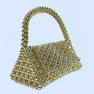 Detailed close-up of handmade gold beaded shoulder bag with woven openwork structure
