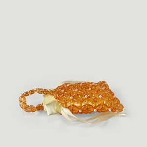 Detail of orange acrylic flower beads with faux pearl center and yellow satin lining