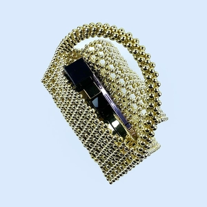 Detailed view of golden beaded handbag showing interior space with phone and lipstick