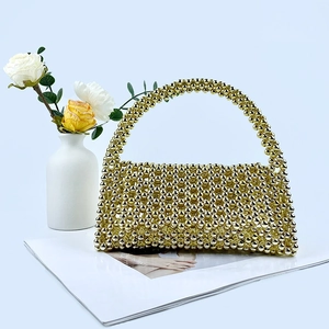 Macro detail of golden beaded handbag with metallic beads and trapezoid woven structure