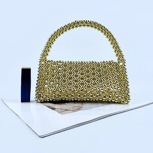 Detailed view of handmade gold beaded evening bag with polished metallic beads and handle