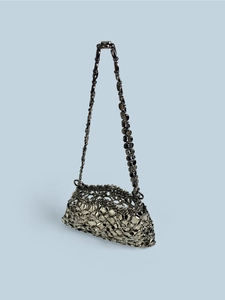 Detailed view of dark metal sequins and chain link texture on a silver-black shoulder bag