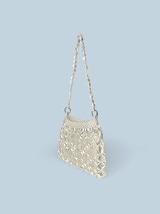 Detail of beaded handbag showing white sequins, square patterns, and metal rings with strap