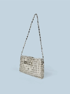 Detailed view of silver sequin hand-woven texture on crossbody bag with metallic chain strap