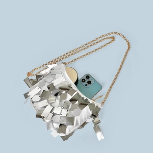 Detailed close-up of a silver sequined evening bag with an elegant golden chain strap