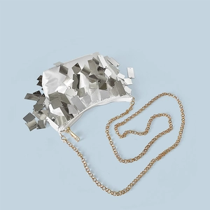 Detailed shot of silver fringe sequins and golden chain strap on a vintage evening clutch bag