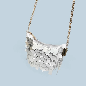 Detail of silver metallic sequins and gold chain strap on the luxury crossbody bag