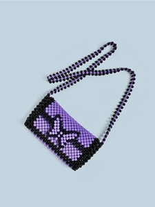 Detail of handmade purple beaded crossbody bag featuring a black woven butterfly motif